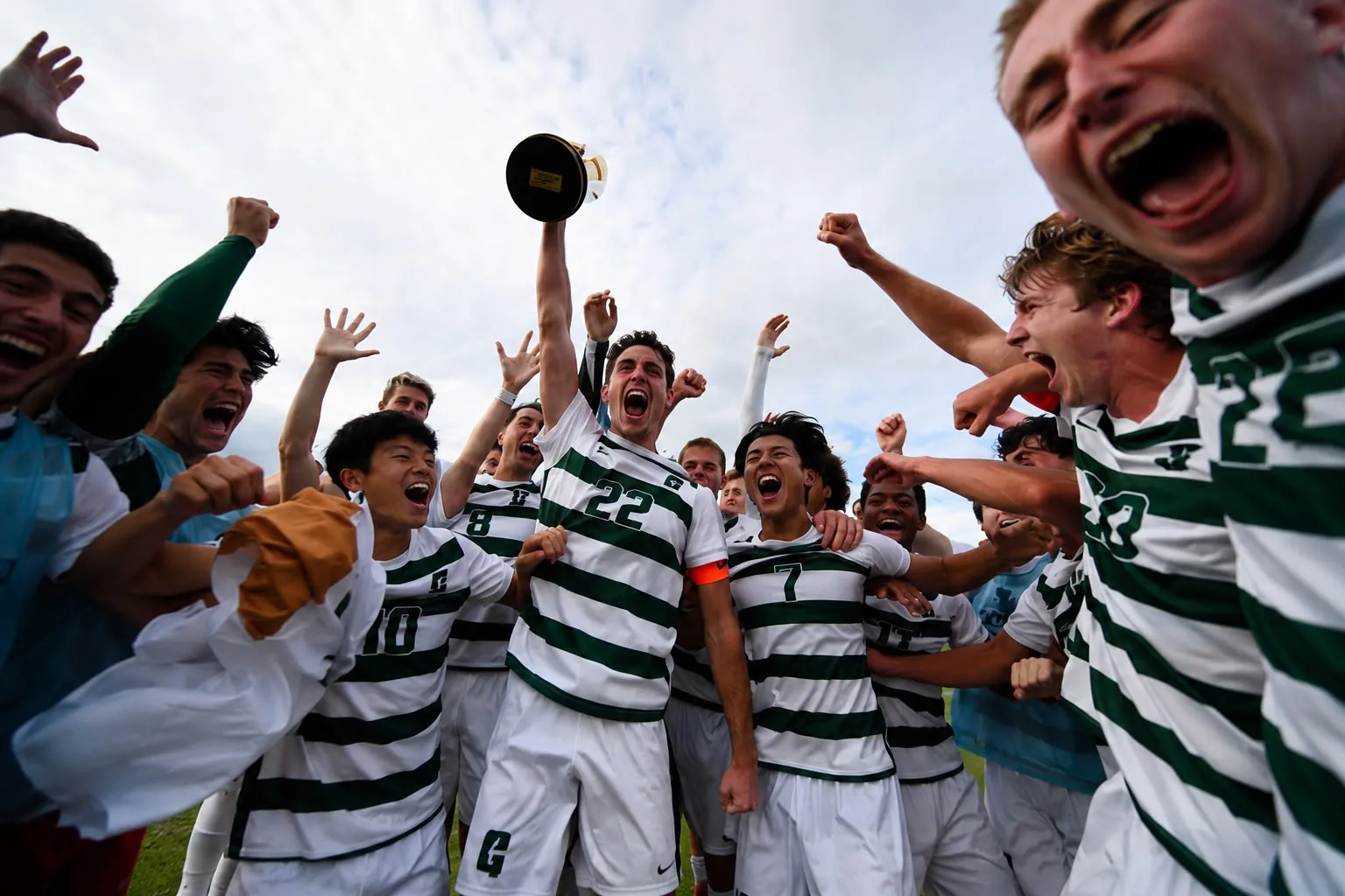 College soccer team lifting the trophy in celebration