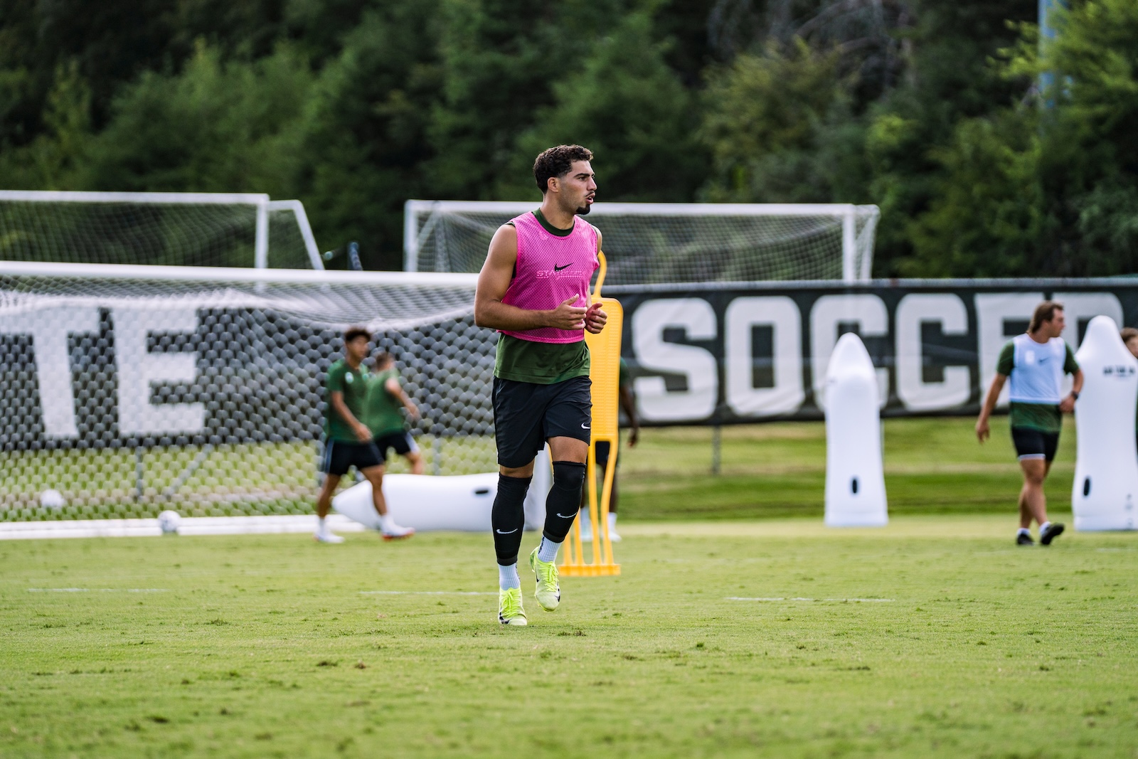 College soccer player jogging across the training pitch